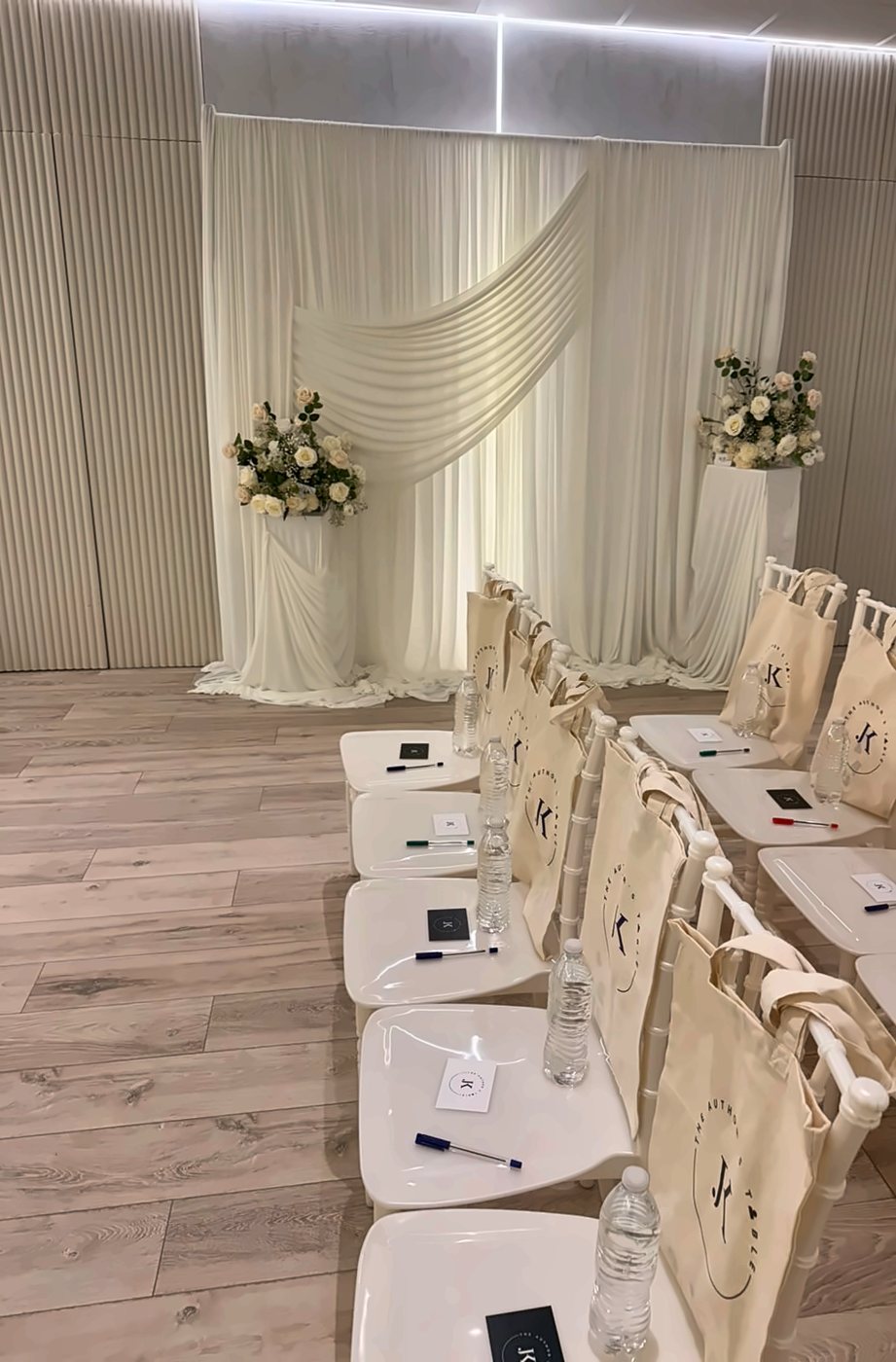Rows of white chairs with gift bags, set for a workshop
